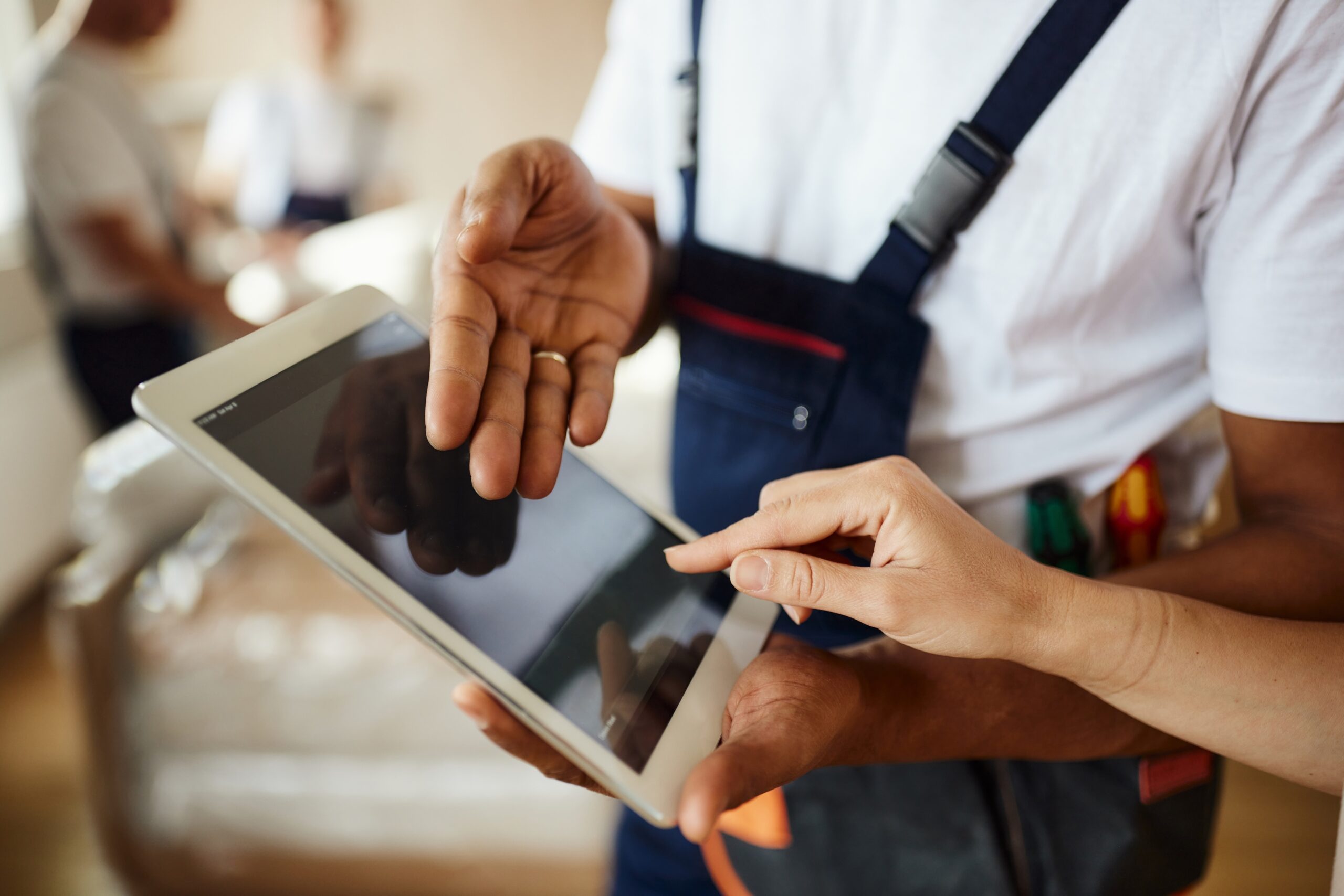 Close up of unrecognizable male worker showing his customer where to put her electronic signature on digital tablet.